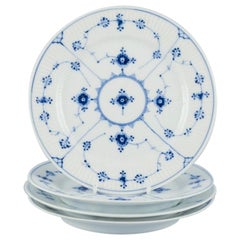 Royal Copenhagen, blau geriffelte Plain. Set aus vier Tellern. 1920er/30er Jahre.