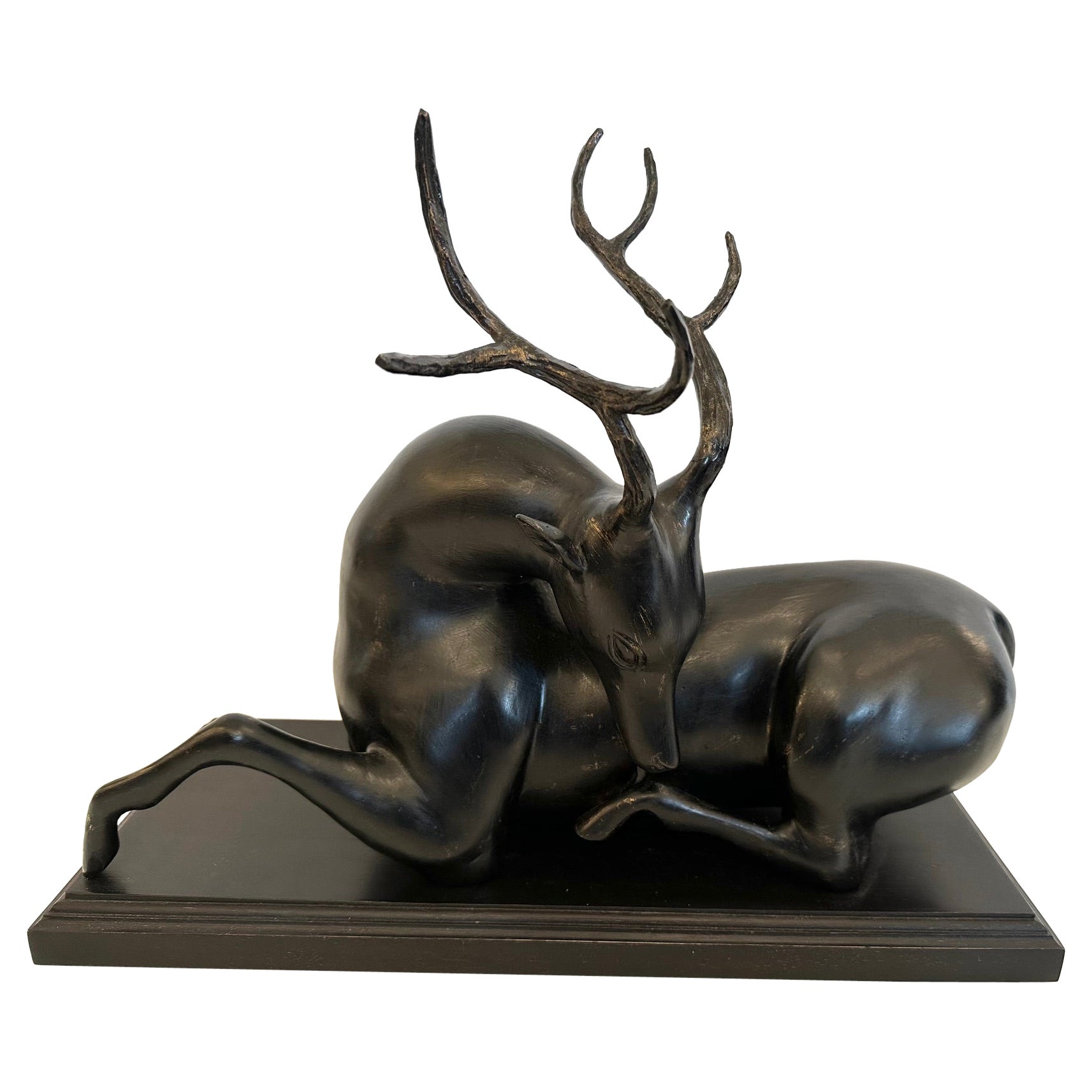 Sculpture poétique de cerf cabré couché sur socle en bois