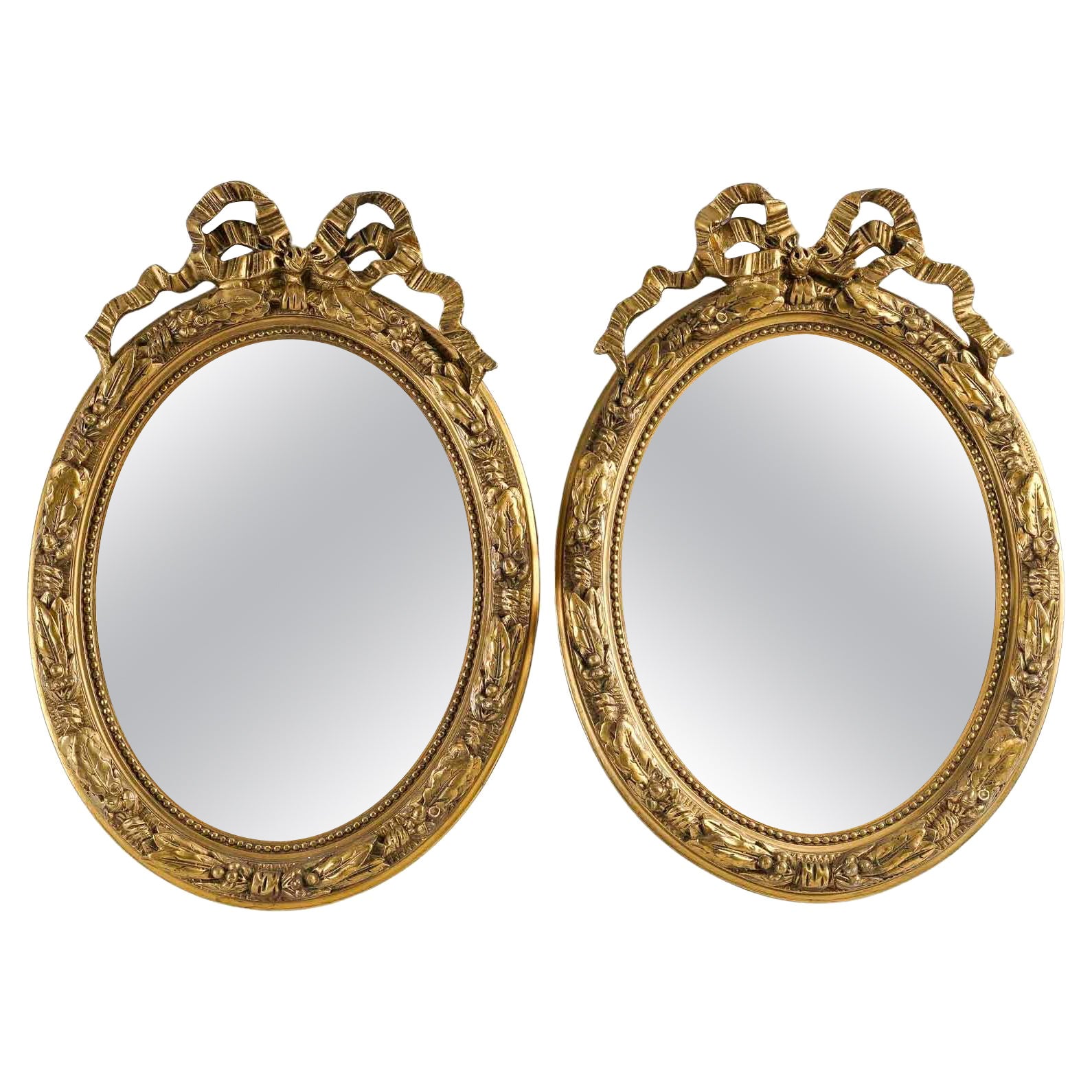 Paire de miroirs de style Louis XVI en bois et stuc doré, début du 20e siècle.