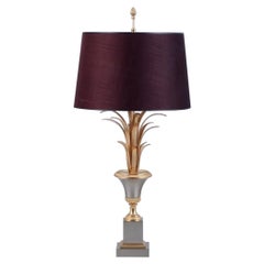 Table lamp in brass with base in the shape of palm leaves and textile shade.