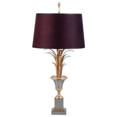 Grande lampada da tavolo in ottone con base a forma di foglie di palma.