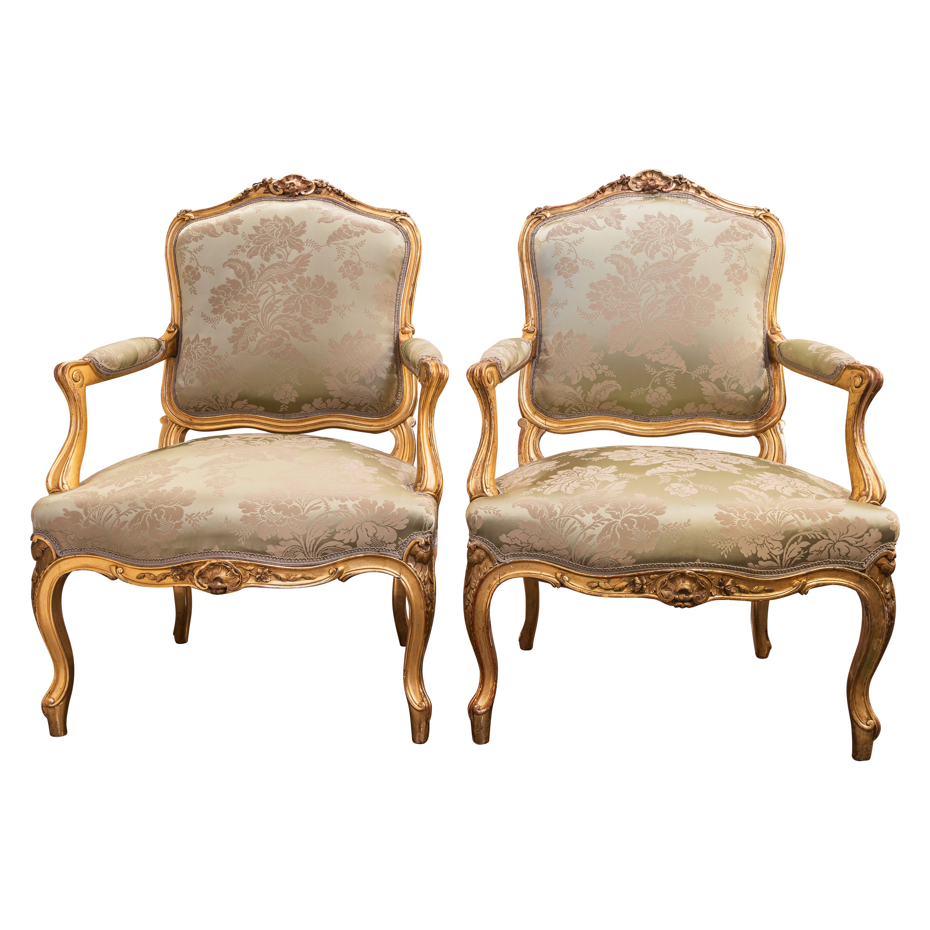 A fine pair of 19th c Louis XV water gilt fauteuils . Fine carving with a silk  For Sale