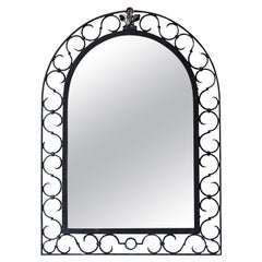 Miroir arqué en fer français avec motifs ajourés en forme de volute en S et crête de feuillage