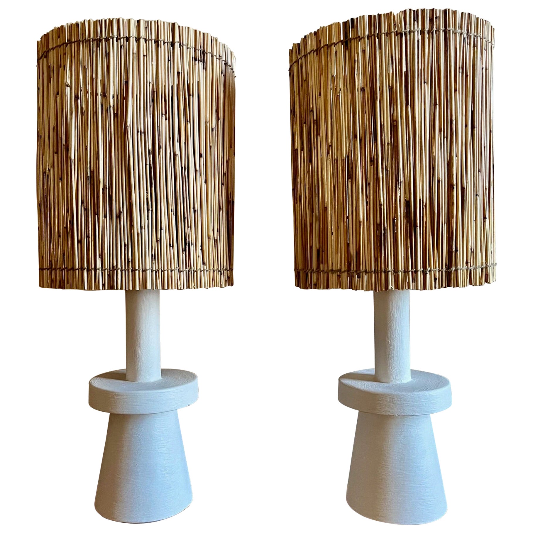 Pair of stuccoed plaster table lamps with straw shades