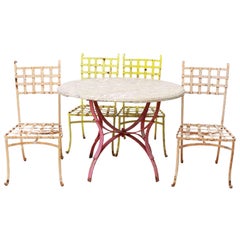 Vieille table de patio française avec base en fer forgé et ensemble de quatre chaises