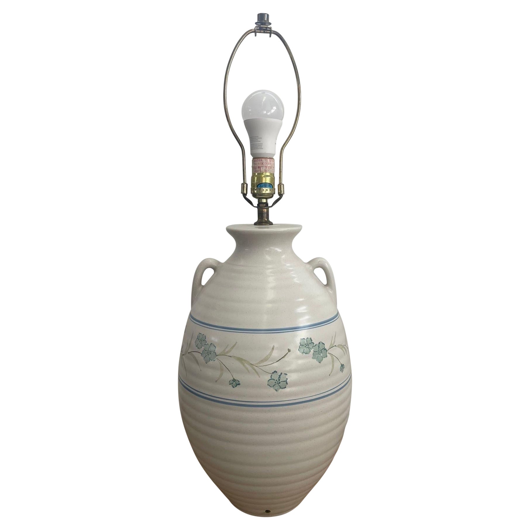 Lampe vintage avec base en céramique et motif floral.
