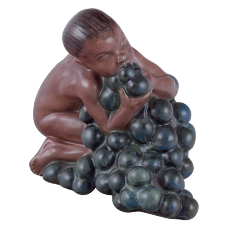 Kai Nielsen for Bing & Grøndahl. Stoneware figurine. Little Bacchus with Grapes. For Sale