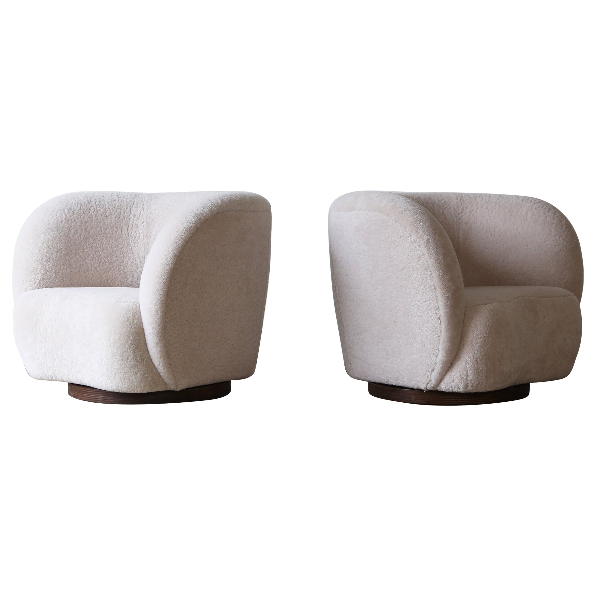 A Pair of Swivel Lounge Chairs in Natural Sheepskin Upholstery