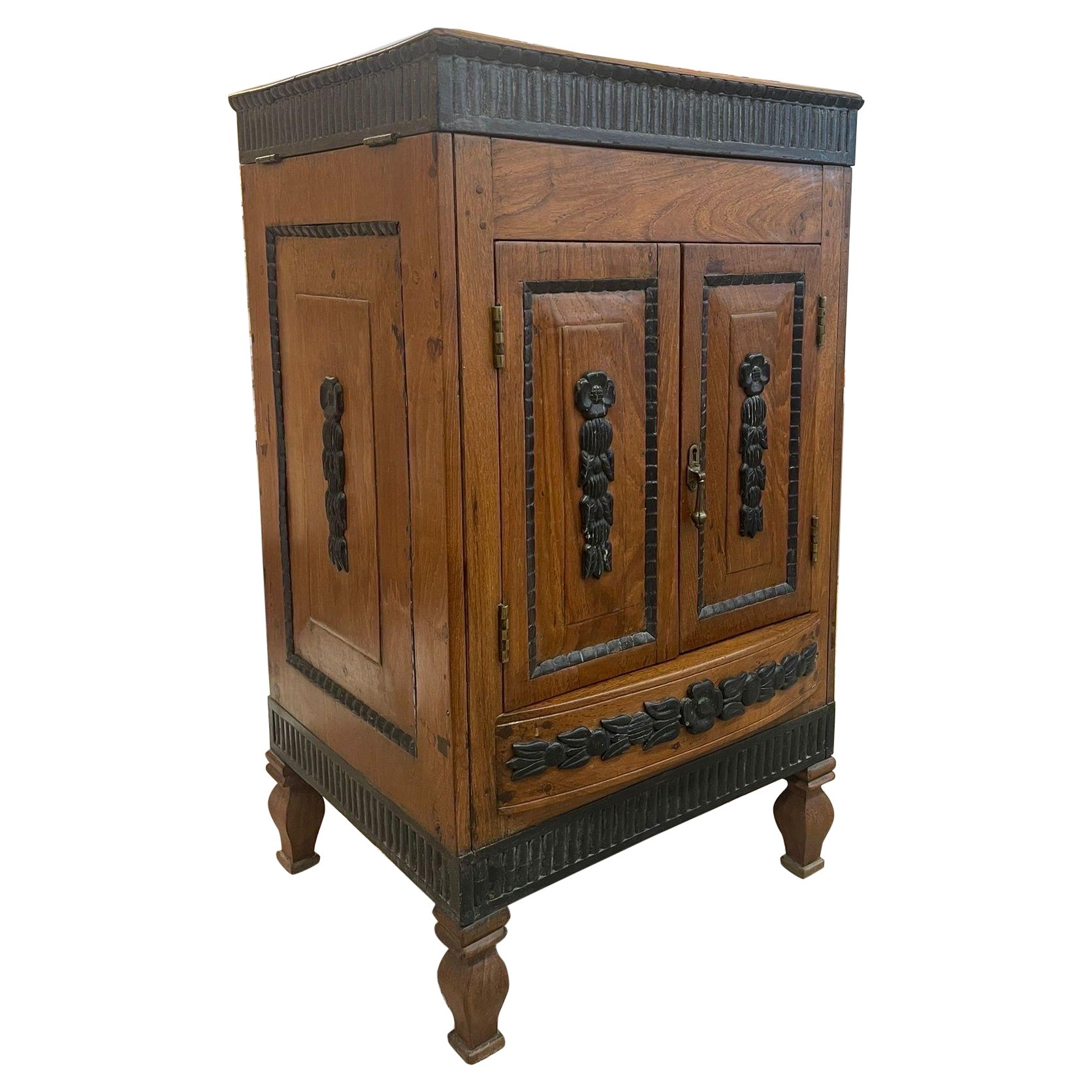 Vieille armoire de style colonial néerlandais avec accents en bois sculpté.