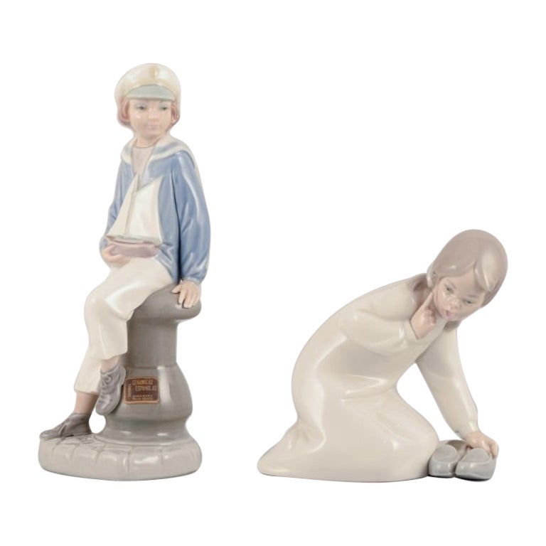 Lladro, Spain. Two porcelain figurines. Boy in a sailor outfit and a girl.