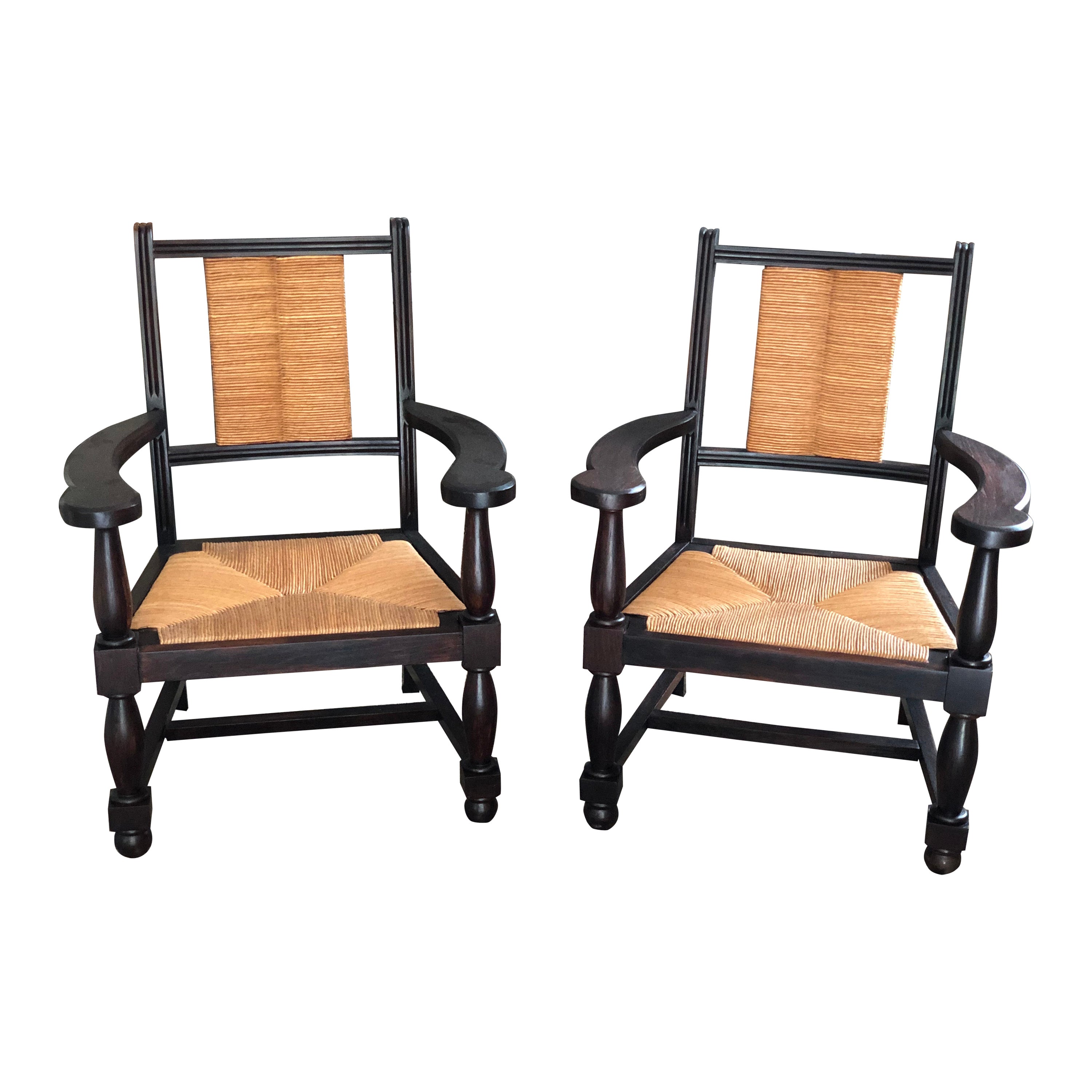 Pair of 1950s vintage Neo-Basque oak armchairs, straw-bedecked seats and backs. For Sale