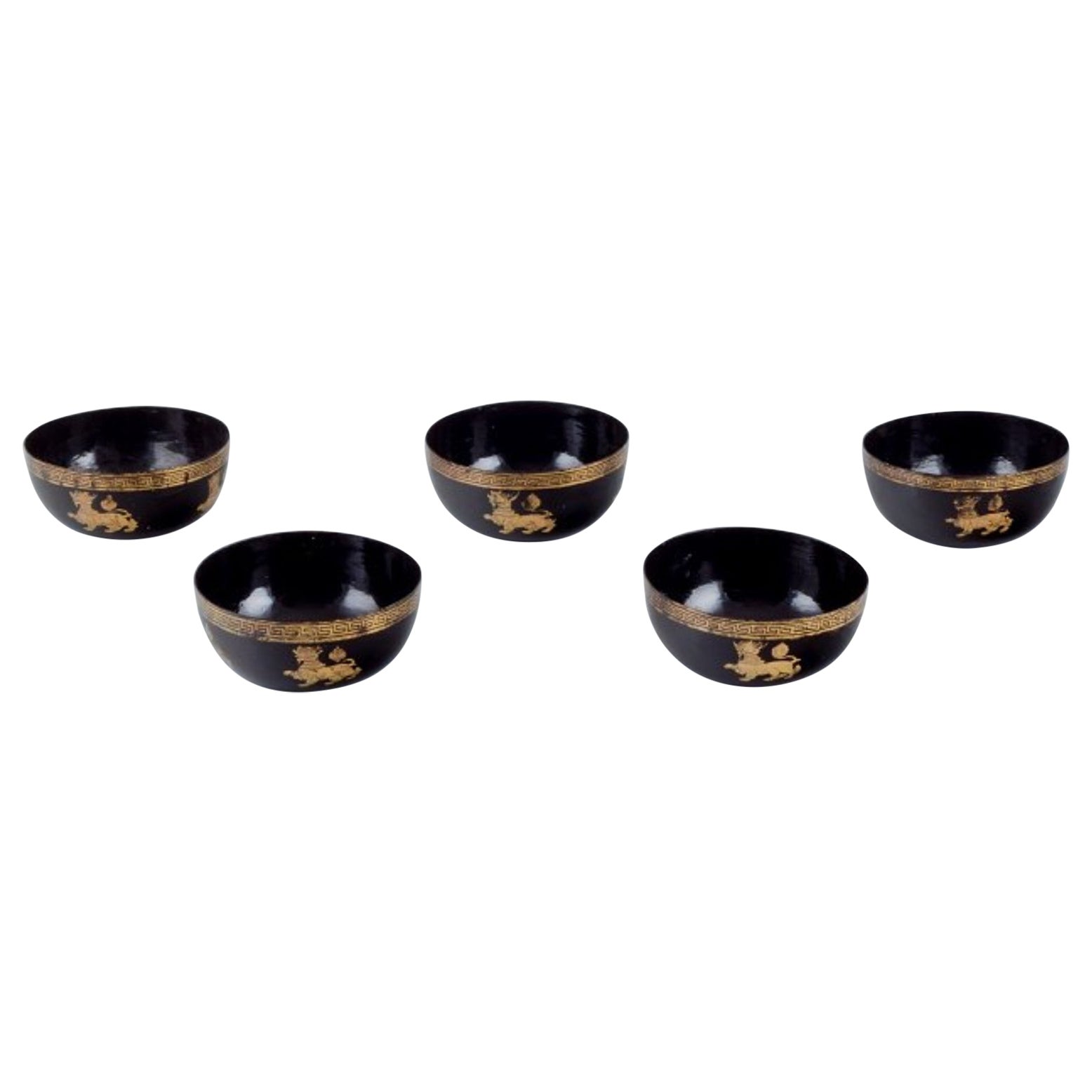Five Asian bowls made of papier-mâché. Decorated in gold and black.