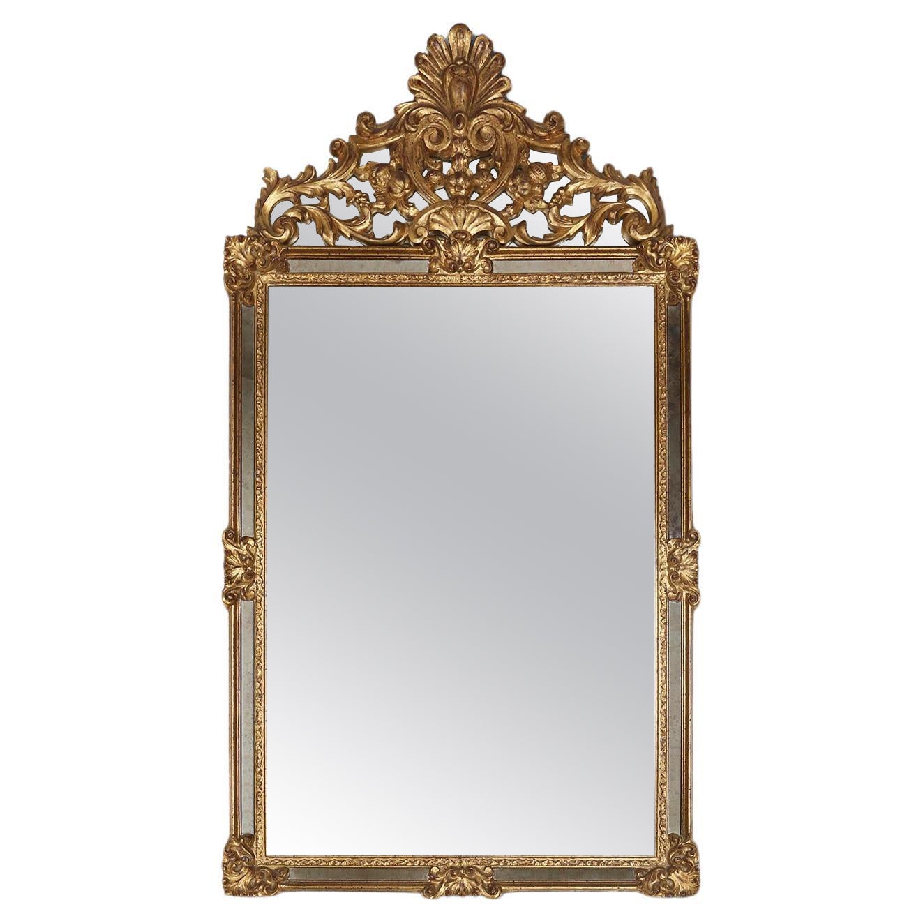 Large elegant gilted mirror with stunning ornamentation on the top, Deknudt  For Sale