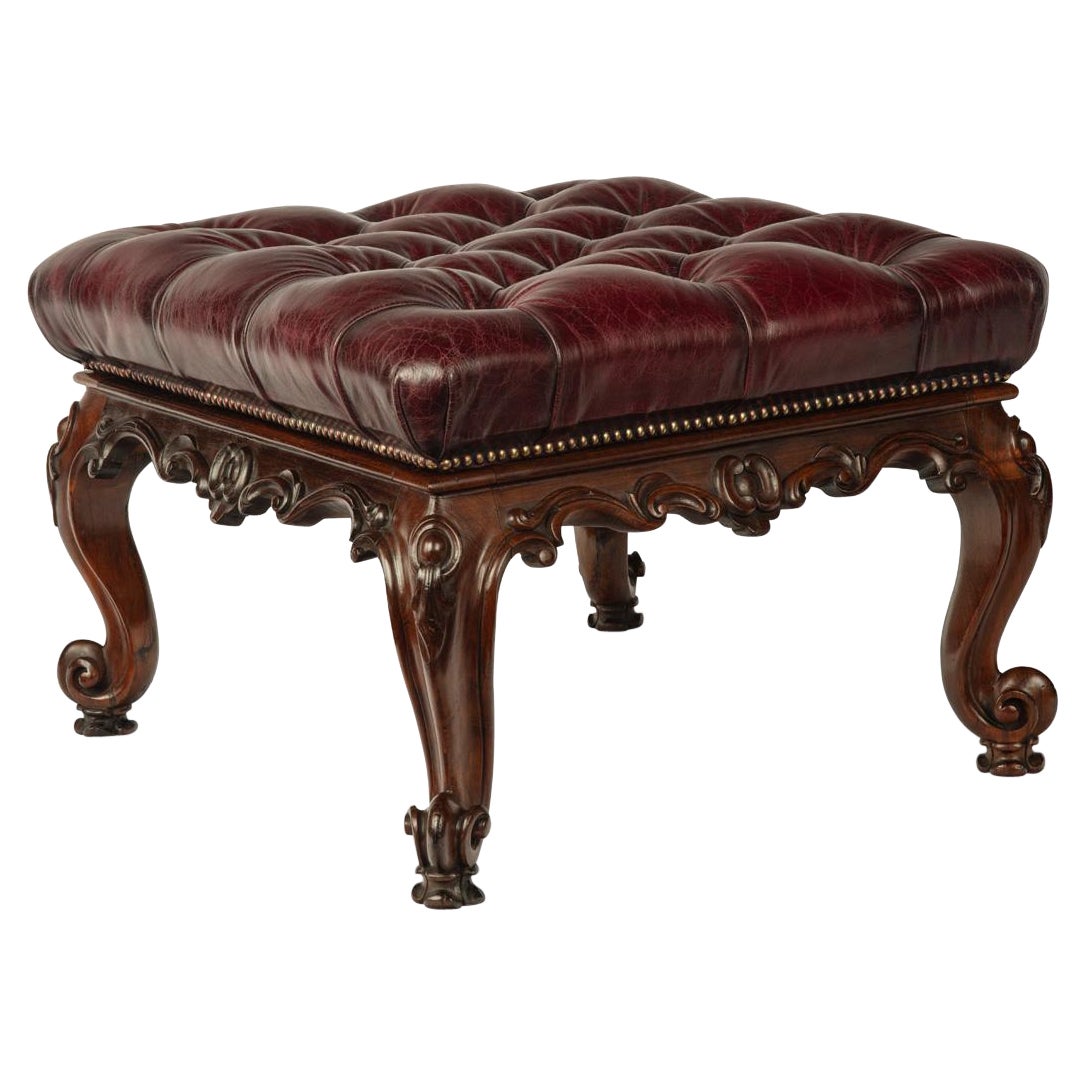 An early Victorian leather-upholstered rosewood stool