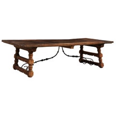 Un robusto tavolo da pranzo italiano lungo 9,5 piedi con gambe a cavalletto intagliate e barella in ferro