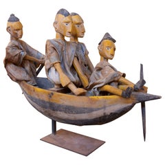 In Holz geschnitzte Skulptur von Figuren in einem Boot mit Stoffkostümen