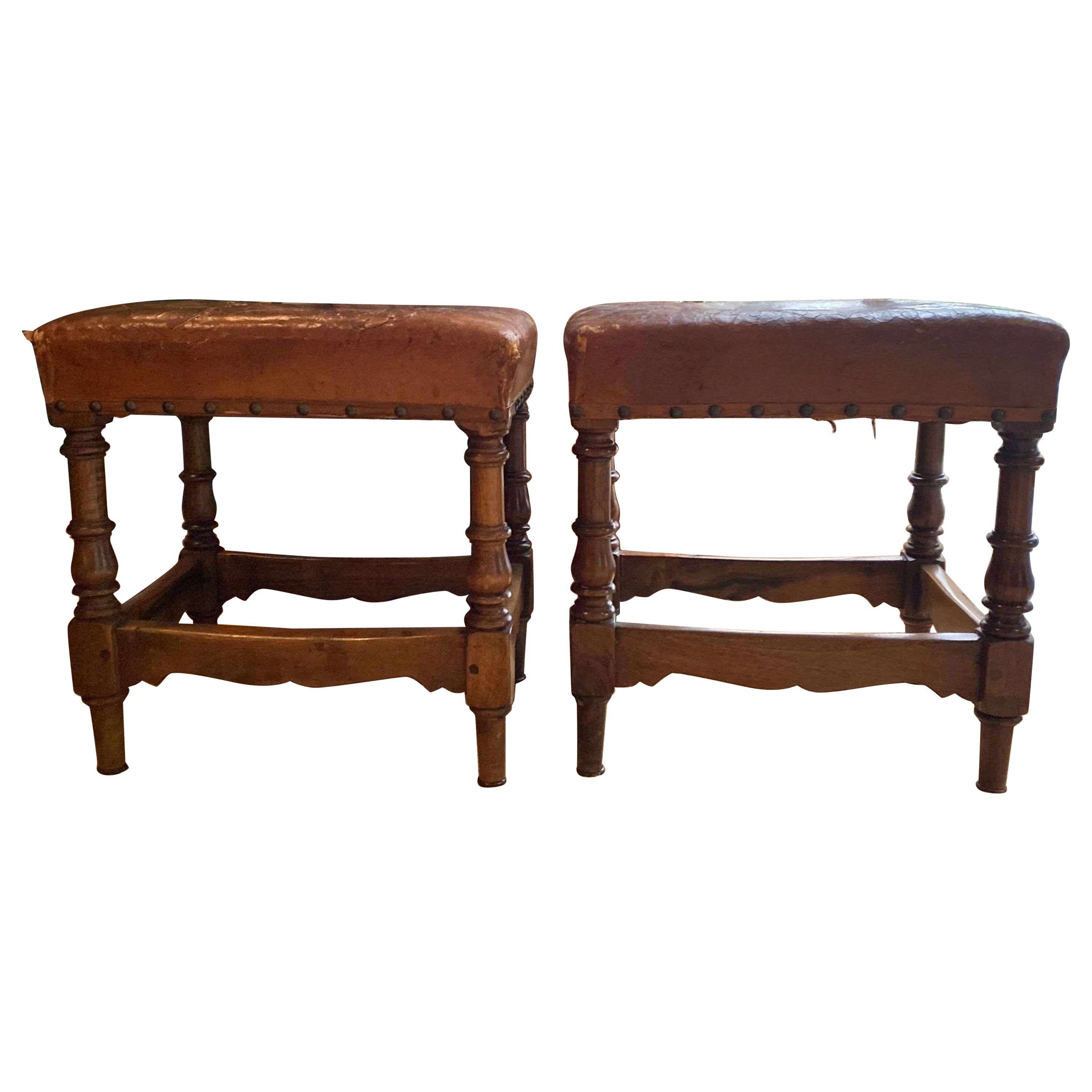 A pair of George V leather upholstered fireside stools with nail head trim.  For Sale