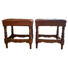 A pair of George V leather upholstered fireside stools with nail head trim. 