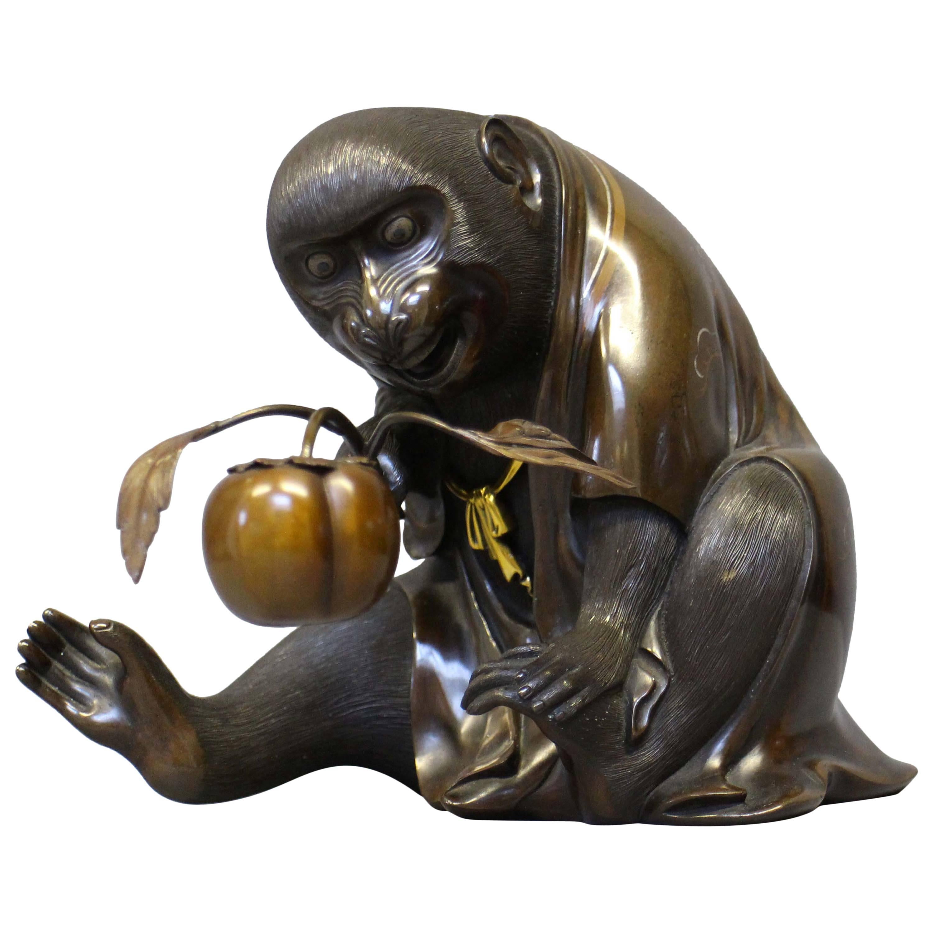 An unusual Antique Japanese Bronze Monkey in an origami kimono holding a peach For Sale