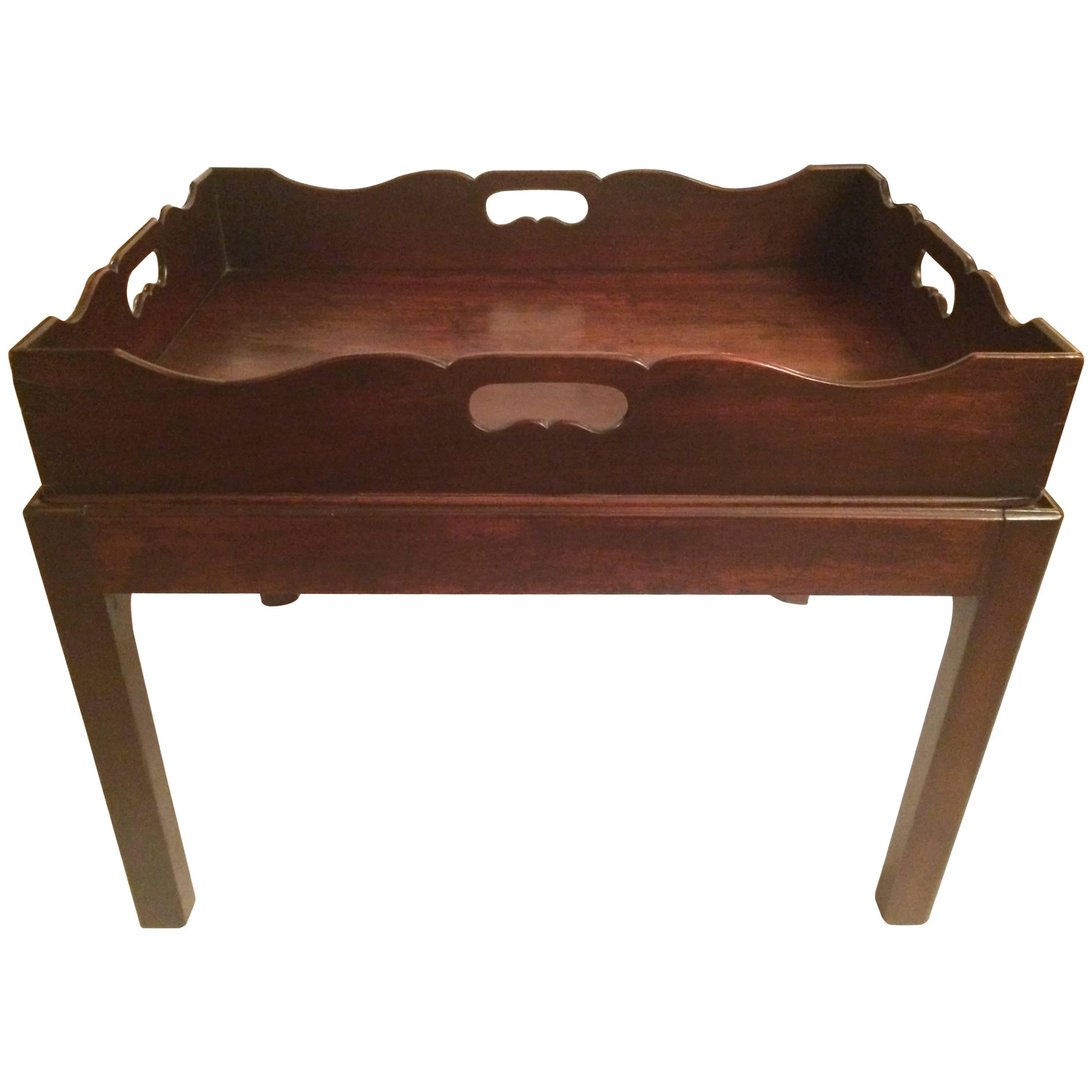English George III mahogany tray on stand (tray table), circa 1850. Scalloped shaped gallery and pierced carrying handles.