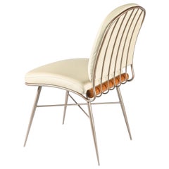 Silla "Cuore" de acero al carbono dorado mate, tapizada en piel Detalle de madera