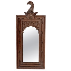 A Gothic Revival oak mirror surmounted with a carved eagle to the top