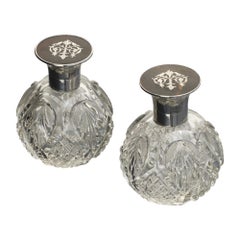 Pair of antique cut glass perfume bottles with silver & tortoiseshell covers