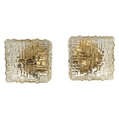 Paar quadratische Wandleuchten aus geformtem Klarglas und goldlackiertem Eisen