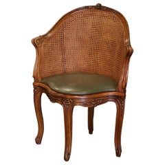 Sillón de escritorio francés Luis XV del siglo XIX, de nogal tallado y caña, con cojín