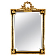 Gran espejo de pared de madera dorada y ebonizada de estilo Imperio francés del siglo XX