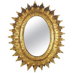 Gran espejo oval francés Sunburst de metal dorado con marco de doble hoja, años 50