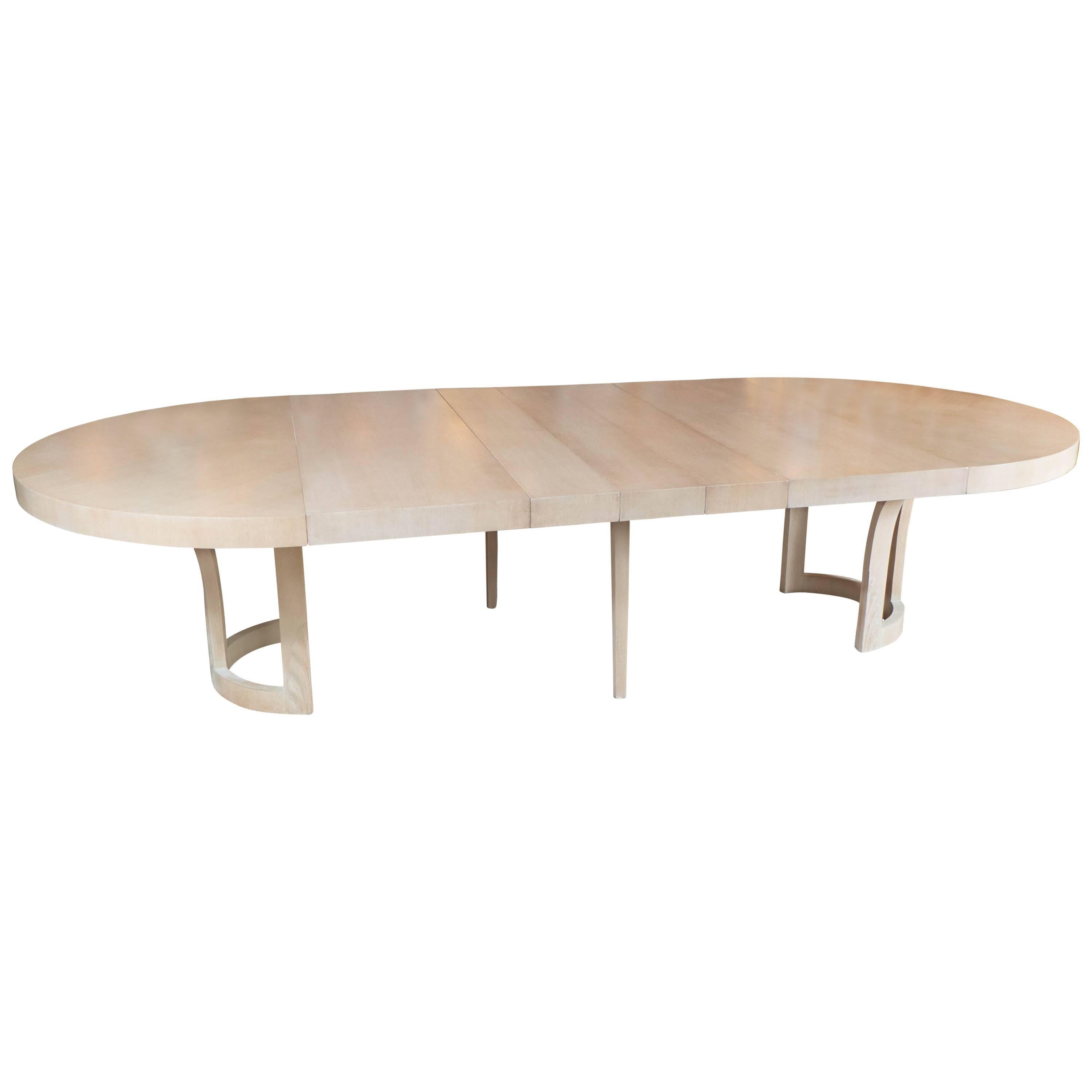A gorgeous and very rare extendable dining table in bookmatched cerused white oak for Schmieg & Kotzian by Dorothy Draper. A decorative foliage pattern stems from its base. A very sturdy yet graceful design by one of America's Hollywood