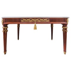 Un raffinato tavolo da sala francese Luigi XVI del XIX secolo, in mogano e bronzo dorato, montato al centro.