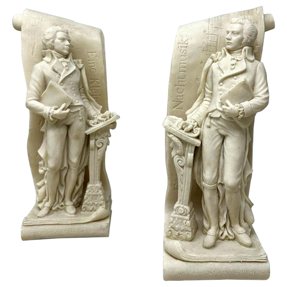 Élégante paire de serre-livres figuratifs de style Grand Tour représentant deux vues masculines du compositeur de musique Wolfgang Amadeus Mozart. En tenue d'époque, chacun d'eux est flanqué d'un lutrin au-dessus d'un piédestal décoratif. Circa