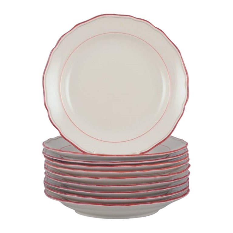 Meissen, Alemania. Juego de diez platos de porcelana con ribete rojo coral.