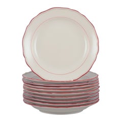 Meissen, Alemania. Juego de diez platos de porcelana con ribete rojo coral.