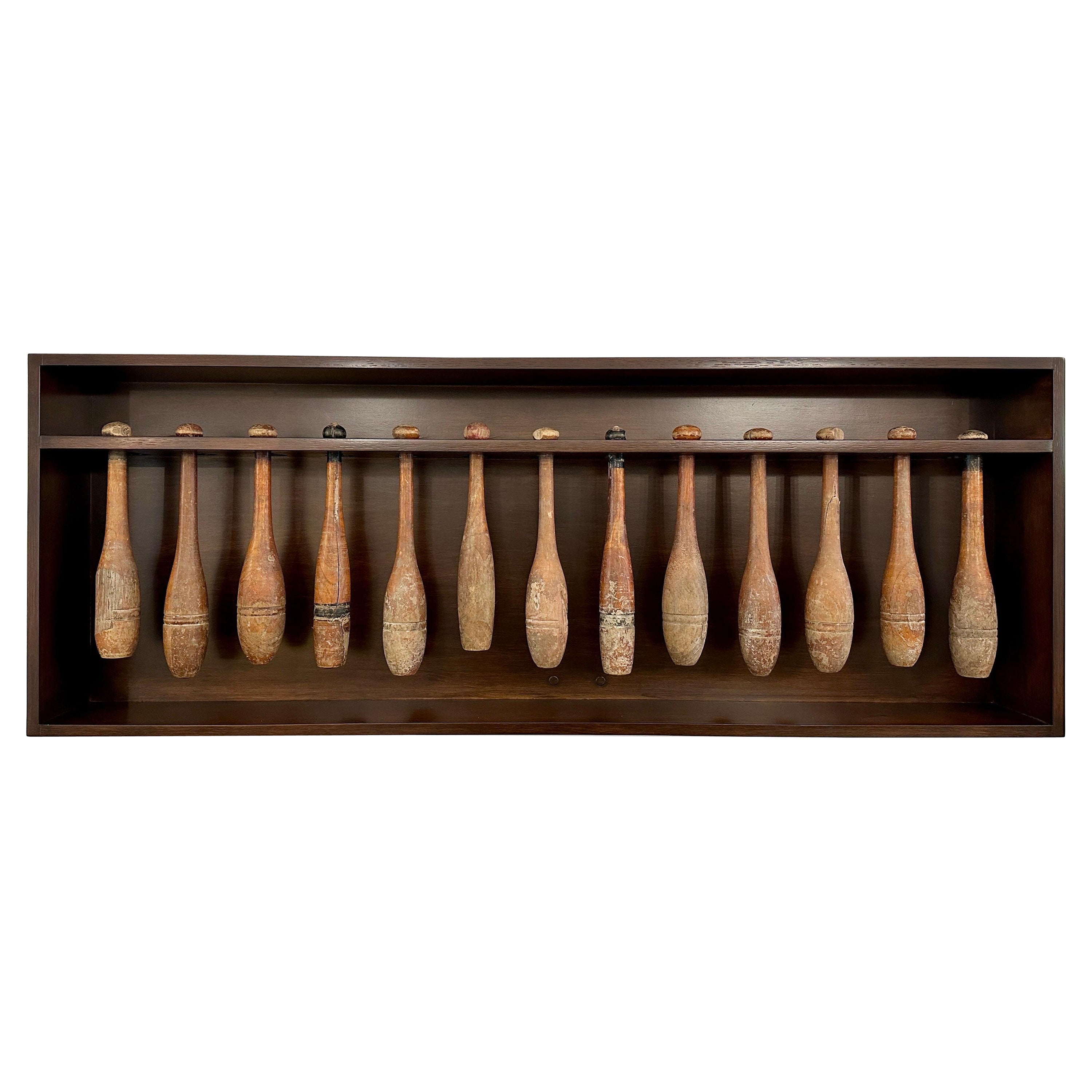 Colección de 13 pasadores malabares de principios del siglo XX en caja expositora de pared