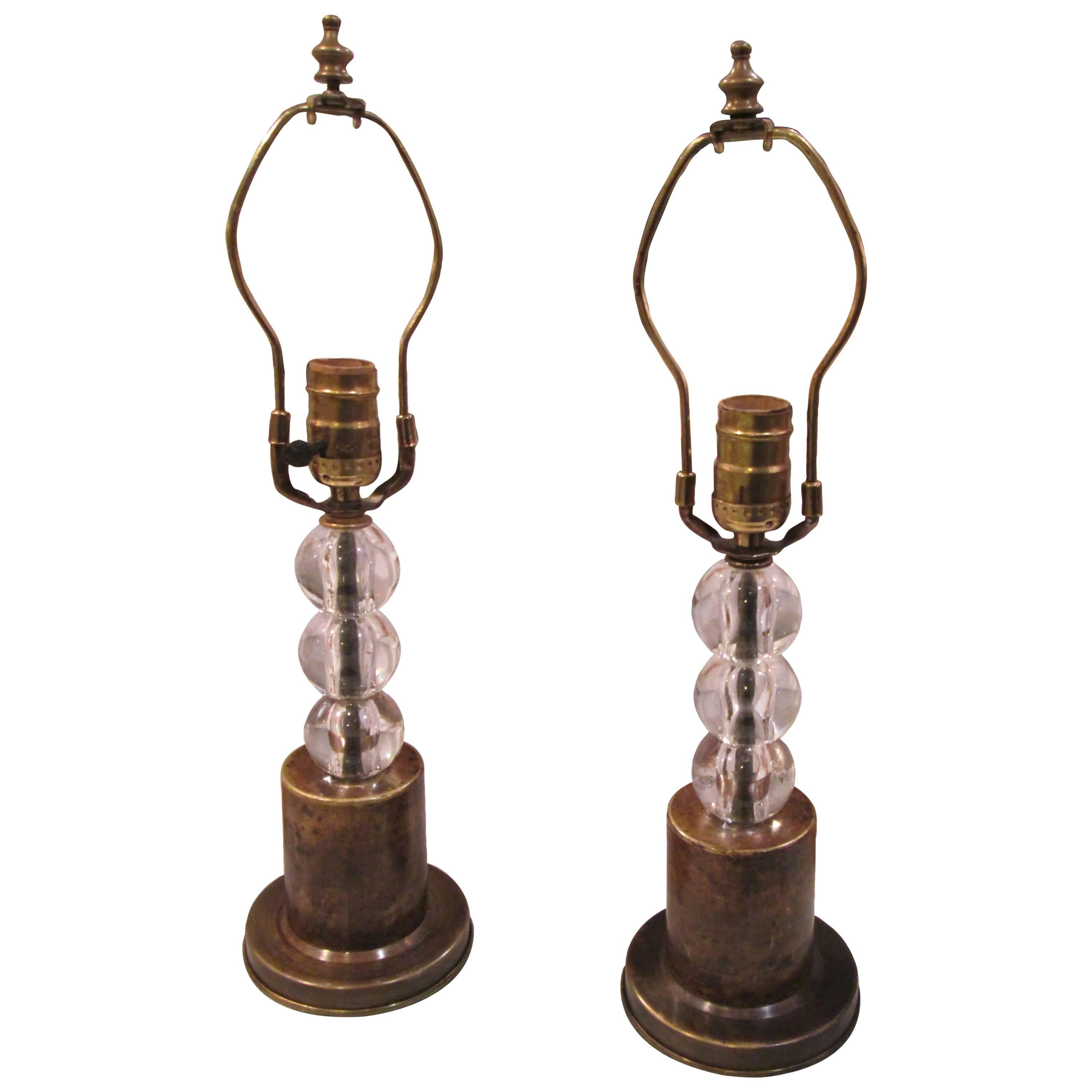 A pair of boudoir lamps with crystal orbs on brass base.