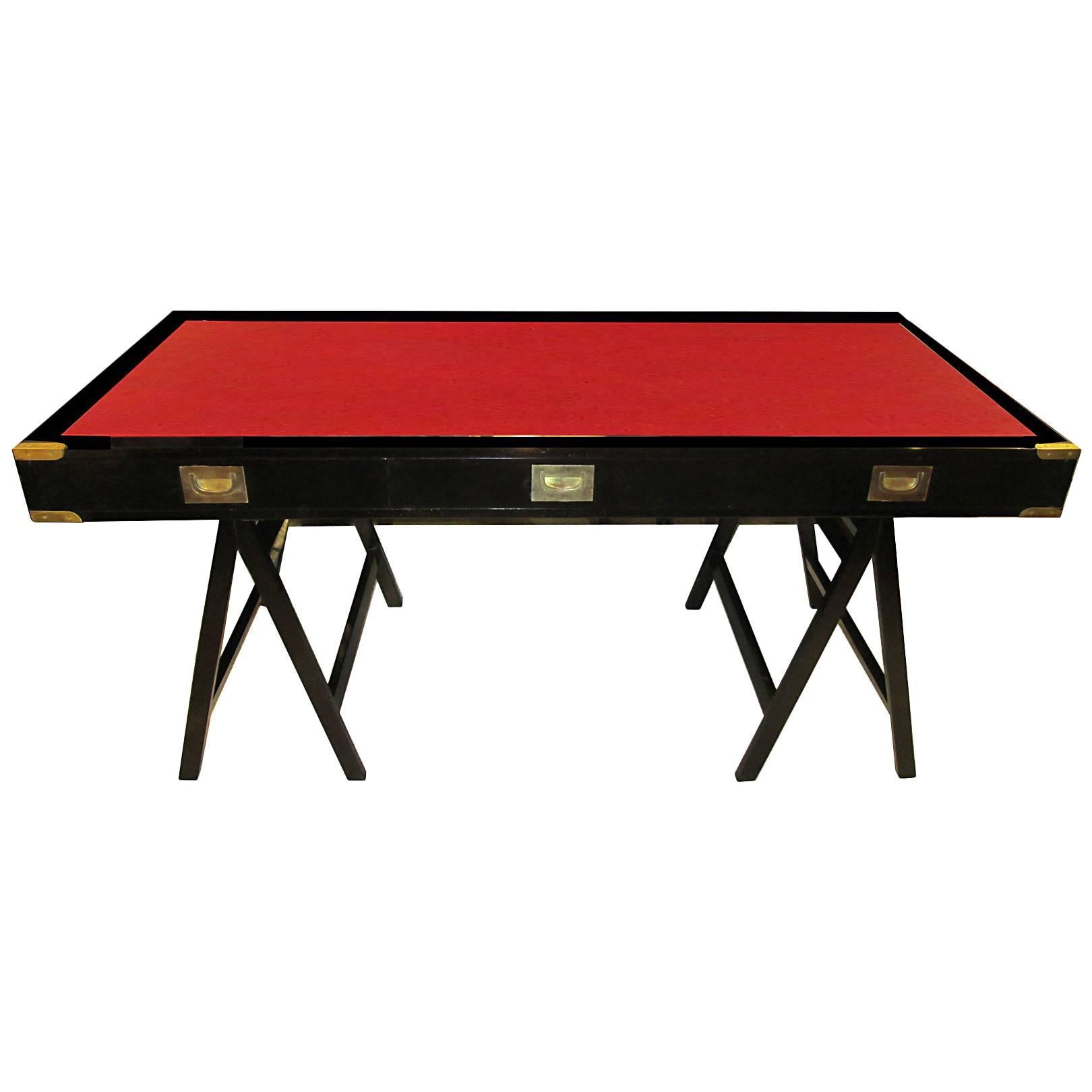 French midcentury ebonized campaign desk with red leather top.