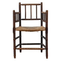 Early 20th Century Cottage Style Hand-Carved Wooden Bobbin Chair w/ Rattan Seat