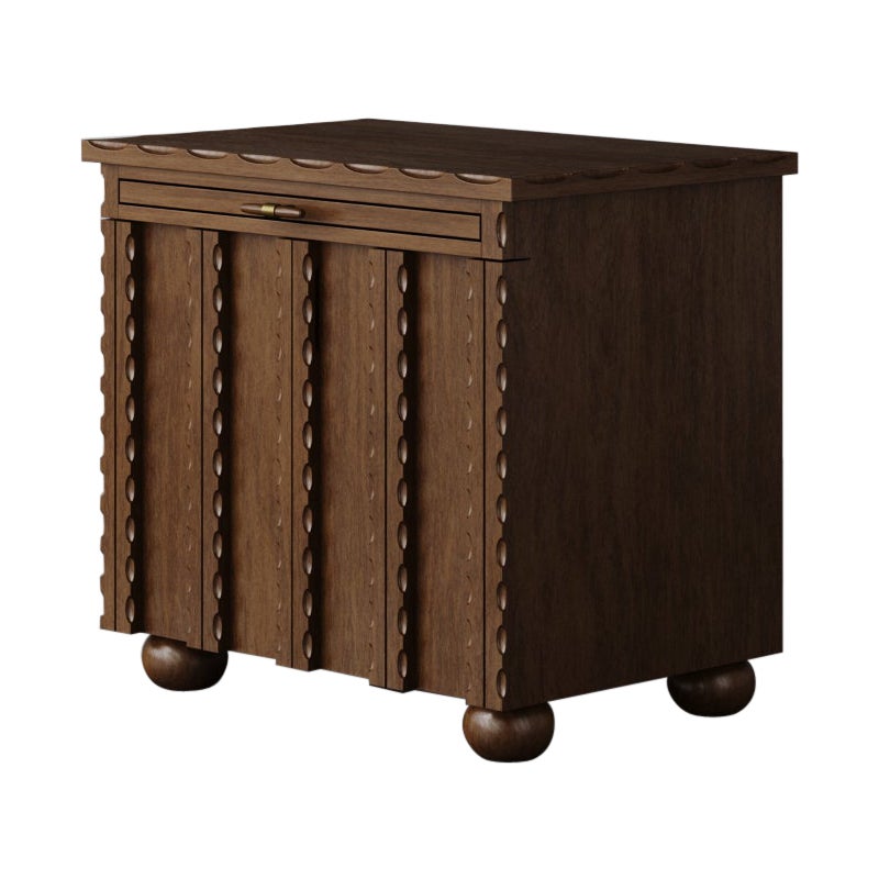 Der Nachttisch Marchand zeichnet sich durch seine eleganten, geschwungenen Kanten und strukturierten Türfronten aus, die ein außergewöhnliches Design für jedes Schlafzimmer darstellen. Er ist mit einem ausziehbaren Regal für zusätzlichen Stauraum am