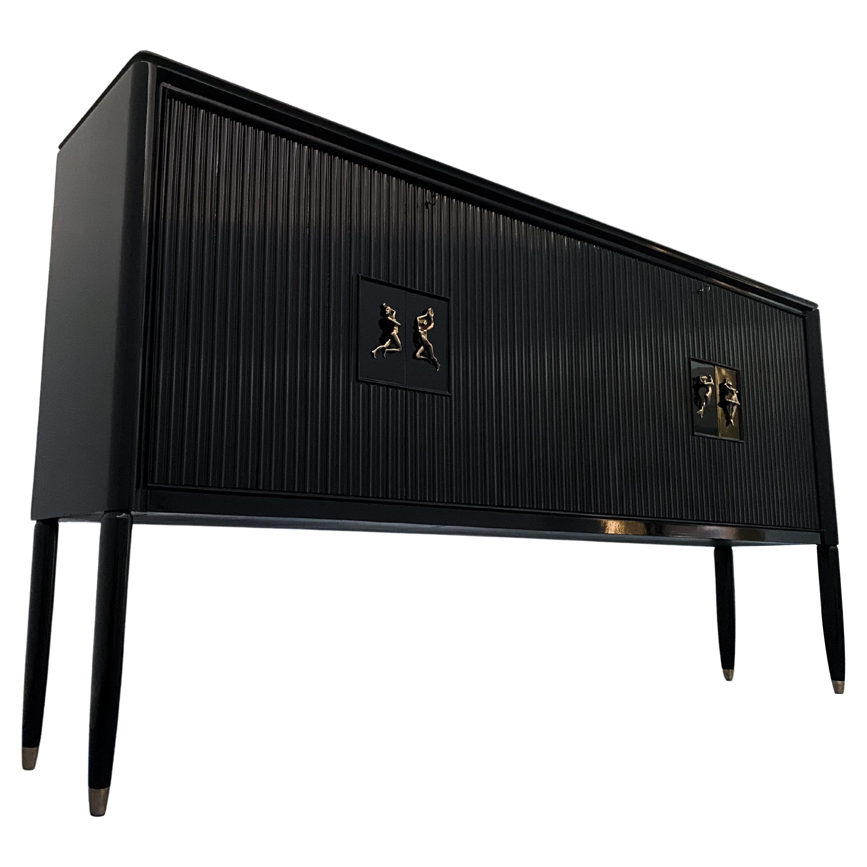 Precioso  Aparador diseñado por Osvaldo Borsani en el año 1948, gran calidad ejecutiva en más detalles, el elegante acabado lacado en negro ,las puertas correderas con refinado Frente Grissinato, los preciosos tiradores figurativos de latón