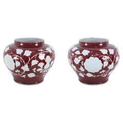 Paire de pots chinois à motifs floraux blancs et bourgognes