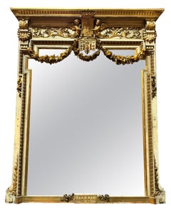 Large mirror in lacquered and gilded wood, richly decorated with friezes, Italy