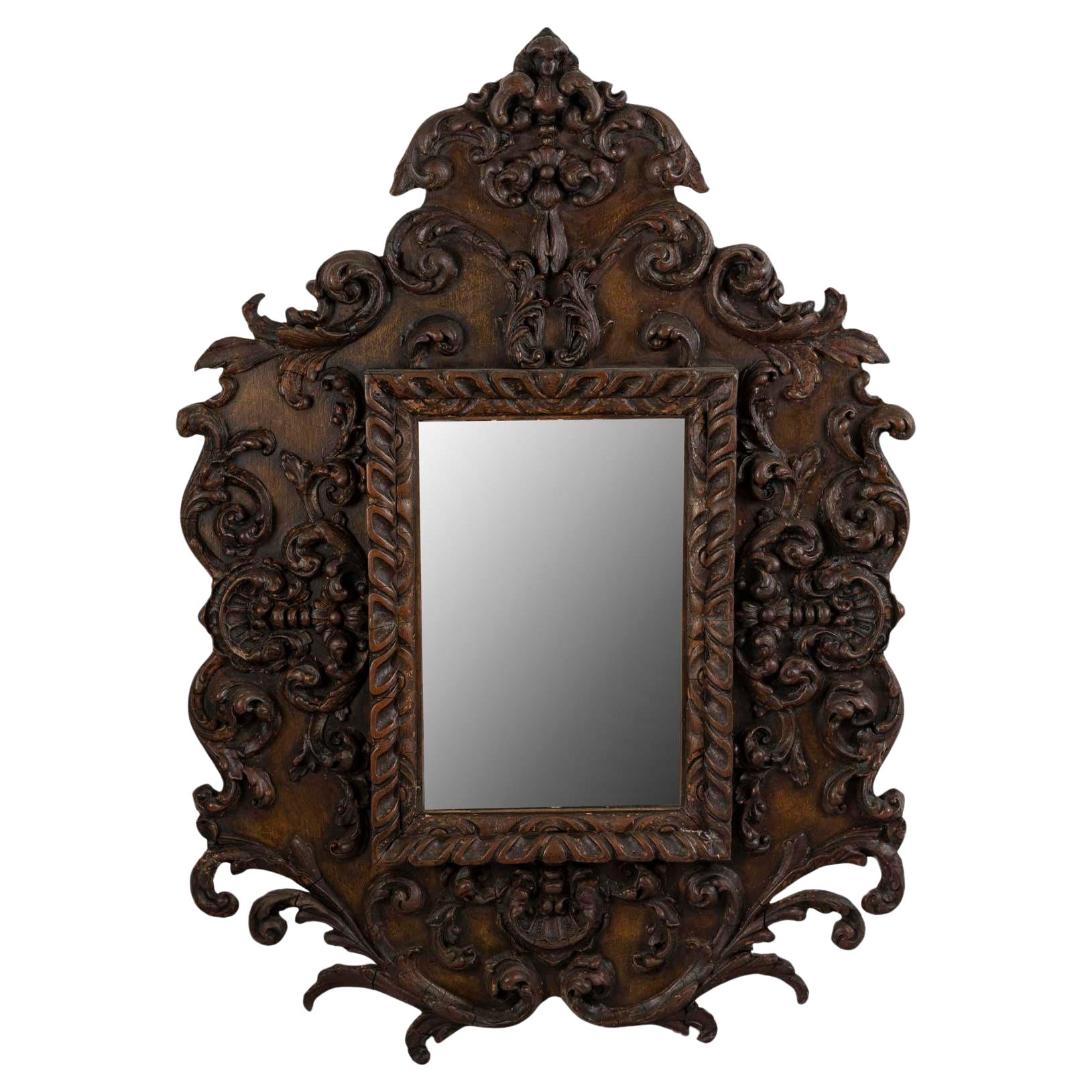 Miroir mural de style Régence baroque en bois sculpté et patiné, 19e siècle.