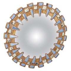 Blue glass and resin convex mirror in the manner of Line Vautrin's Tudor design.