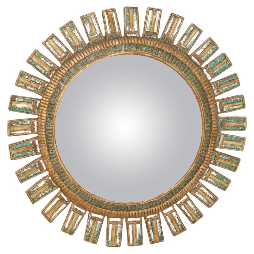 A large green glass and resin convex sunburst mirror.