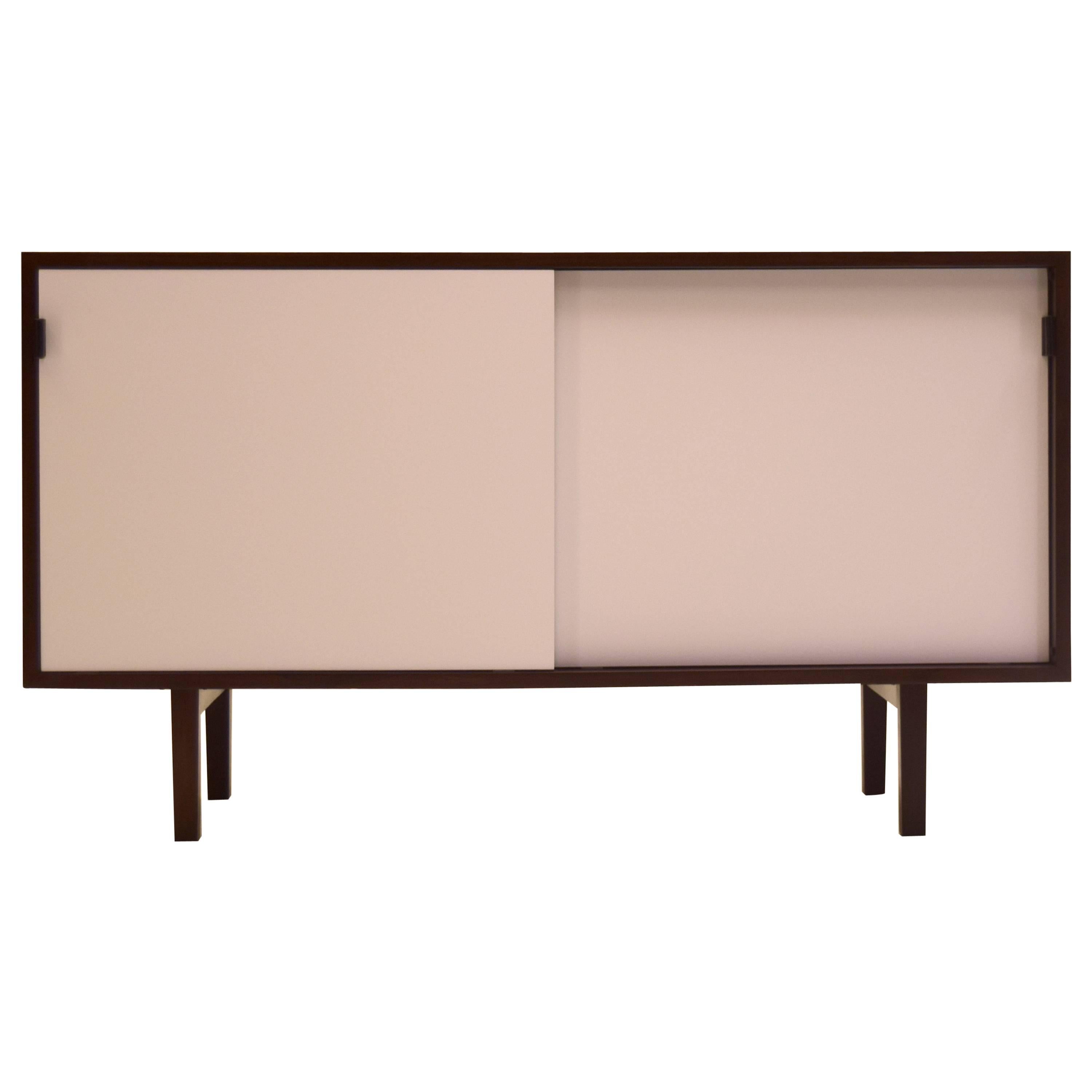 Vintage though nearly like new, this sideboard features white lacquered doors, mortised rosewood and has been out of production for quite some time, circa 1958-1962.

This particular model also features an ebony finished back so can be displayed