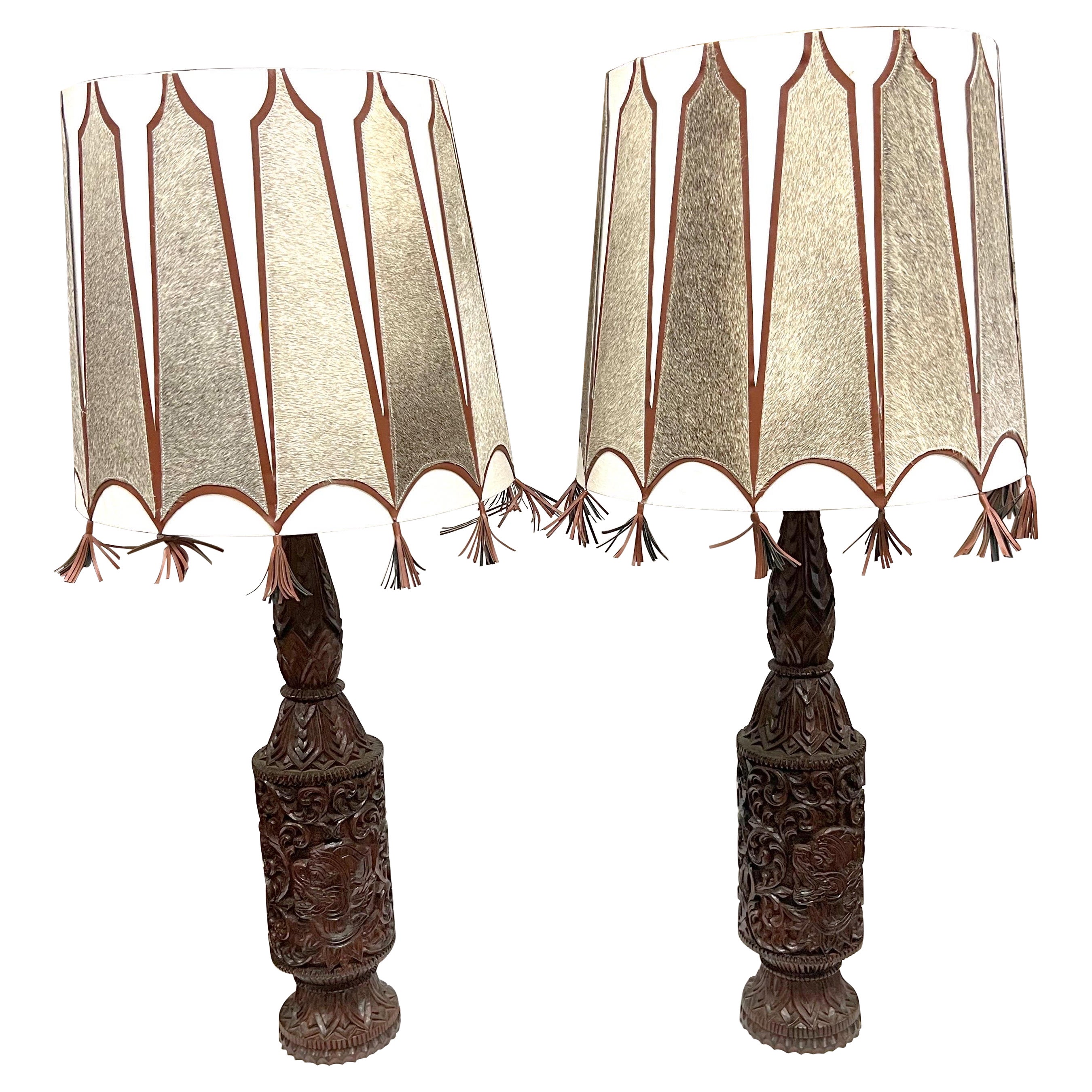 A pair of Mid-Century Tall Carved Wood Relief Lamps With Leather and Fur Shades