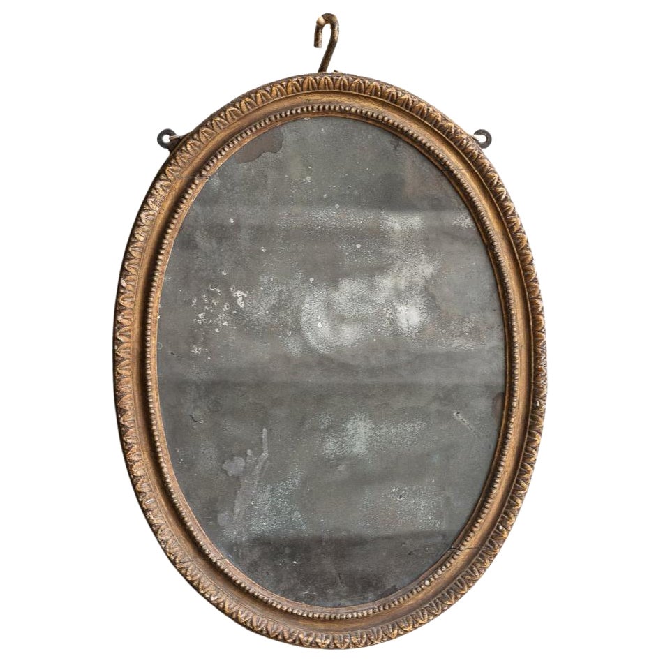 Petit miroir ovale en bois doré sculpté, début du 19e siècle en vente
